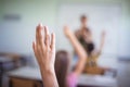 Middle group of students raising their arms to answer the question Royalty Free Stock Photo