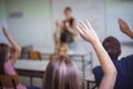 Middle group of students raising their arms to answer the question Royalty Free Stock Photo