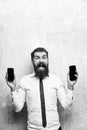 Middle manager. manager or bearded man compare mobile phone and smartphone Royalty Free Stock Photo
