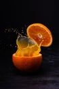 In the middle of an orange a splash of orange juice against the dark background Royalty Free Stock Photo