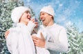 Middle shot of happy cheerful sincerely laughing caucasian couple dressed knitted outfit clothes in the snowy winter forest.