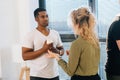 Middle shot portrait of African American male having conversation with young woman colleague during coffee break. Royalty Free Stock Photo