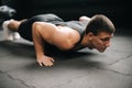 Middle shot portrait of muscular strong man doing push-ups exercise on the floor Royalty Free Stock Photo