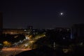 Midnight moon over a city intersection Royalty Free Stock Photo