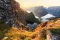 Radiant glow from the midnight sun over moss-covered rocks and dramatic peaks in Lofoten