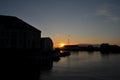 Midnight sunset to the sea in the harbor in Alesund, Norway. Silhouettes of houses, piers, boats and lighthouse at midnight on the