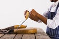 Midsection of african american male chef grating cheese at table by white background, copy space Royalty Free Stock Photo