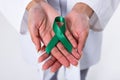 Midsection of african american mid adult female doctor with green mental health awareness ribbon