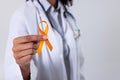 Midsection of african american mid adult female doctor with yellow sarcoma cancer awareness ribbon Royalty Free Stock Photo