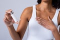 Midsection of african american mid adult female holding asthma inhaler against white background