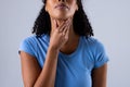 Midsection of african american mid adult woman touching painful throat against white background