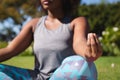 Midsection of african american woman practicing yoga in sunny garden