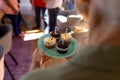 Midsection of asian senior woman holding plate with cupcakes and candles in nursing home