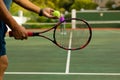 Midsection of biracial senior man holding racket serving tennis ball while playing at tennis court Royalty Free Stock Photo