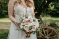 Midsection of bride holding a beautiful bouquet in park outdoors Royalty Free Stock Photo