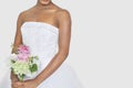 Midsection of bride holding bouquet over gray background Royalty Free Stock Photo