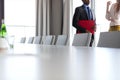 Midsection of businessman and businesswoman standing by conference table in office