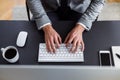 A midsection of businessman with computer sitting at the desk, working. A top view.