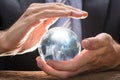 Midsection Of Businessman Covering Crystal Ball