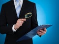 Businessman Examining Document With Magnifying Glass Royalty Free Stock Photo