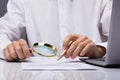 Businessman Examining Invoice With Magnifying Glass Royalty Free Stock Photo