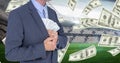 Midsection of businessman hiding money in blazer at football stadium representing corruption