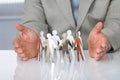 Businessman Protecting Paper Team On Desk