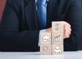 Midsection of businessman and wood blocks with real estate and mortgage investment icons