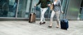 Midsection of businesspeople with luggage going on business trip, running at the airport. Royalty Free Stock Photo