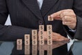 Midsection of businesswoman stacking dollar blocks at desk