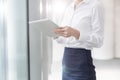 Midsection of businesswoman using digital tablet while standing in boardroom at office