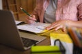 Midsection of caucasian woman sitting at table working in living room, using laptop and making notes Royalty Free Stock Photo