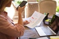 Midsection of caucasian woman working at home, using laptop and smartphone, holding paperwork Royalty Free Stock Photo