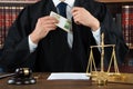 Corrupt Judge Putting Dollar Bundle In Pocket