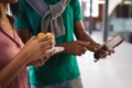 Midsection of diverse business colleagues having snack in office looking at smartphone Royalty Free Stock Photo