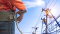 Midsection of electrician lineman wearing safety belt with blurred background of electrical workers team are working on power Royalty Free Stock Photo