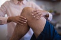 Midsection of female therapist examining knee with senior male patient Royalty Free Stock Photo