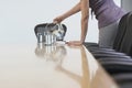 Midsection Of Female Worker Pouring Water Into Glasses On Confer