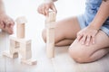 Midsection of girl playing with building blocks on hardwood floor