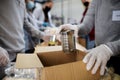 Midsection of group of volunteers in community donation center, food bank and coronavirus concept.