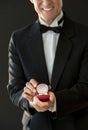 Midsection Of Happy Man In Tuxedo Holding Ring Box