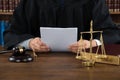 Judge Reading Documents At Desk In Courtroom