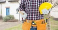 Midsection of male caucasian construction worker wearing tool belt holding hardhat and hammer Royalty Free Stock Photo