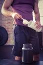 Midsection of man putting supplement into bottle