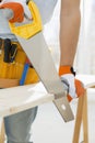 Midsection of man sawing wood in new house Royalty Free Stock Photo