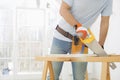 Midsection of man sawing wood in new house Royalty Free Stock Photo