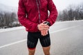 Midsection of man standing outdoor in winter day checking his smart wristwatch for time and hart-rate while training outdoor male