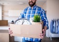 Midsection of mature man with box moving in new unfurnished house.