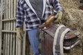 Midsection of a mature man holding horse riding tack