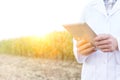 Midsection of mature scientist using digital tablet at farm